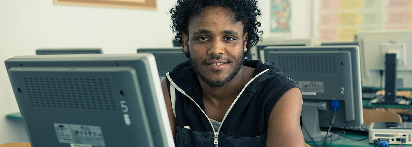 Portrait : Tsegazgi Berhe devant un écran d’ordinateur.