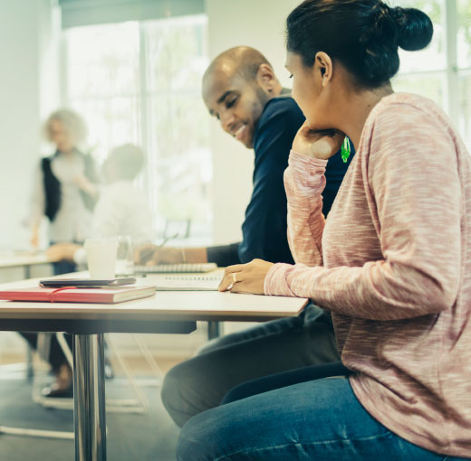 Lesson situation: a young man and young woman sit at a desk in a classroom.