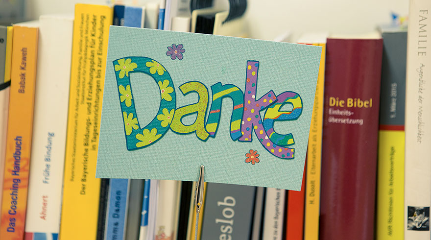 Selbst gebastelte bunte Karte mit der Aufschrift „Danke“.